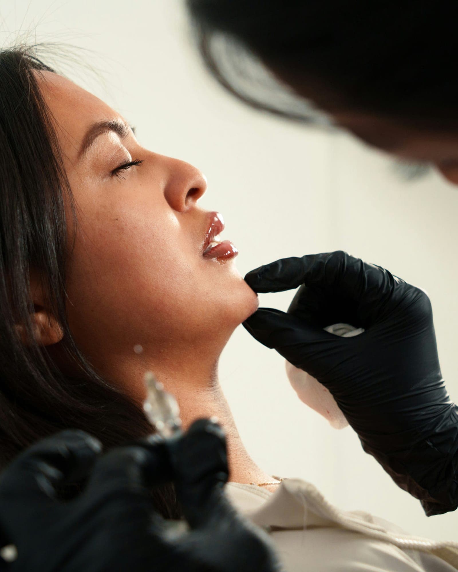 A practitioner assessing a client's face during a consultation